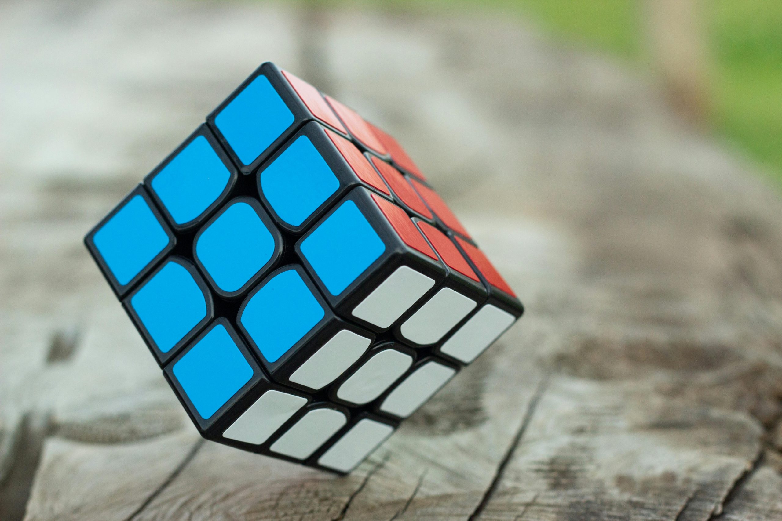 Home Colorful Rubik's Cube resting on a wooden surface, showcasing vibrant geometric patterns.